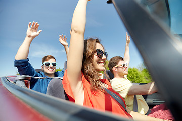 Image showing happy friends driving in cabriolet car at country