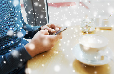 Image showing close up of man with smartphones at cafe