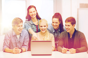 Image showing smiling students looking at laptop at school