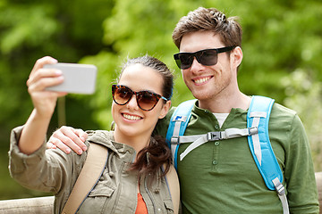 Image showing couple with backpacks taking selfie by smartphone