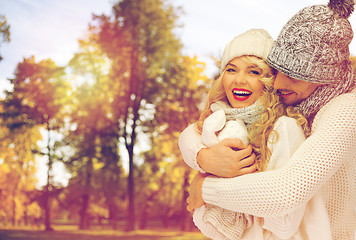 Image showing happy couple in warm clothes over autumn