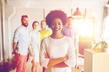 Image showing happy young woman over creative team in office