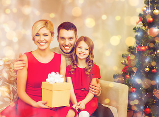 Image showing smiling family holding gift box