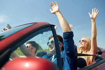 Image showing happy friends driving in cabriolet car at country