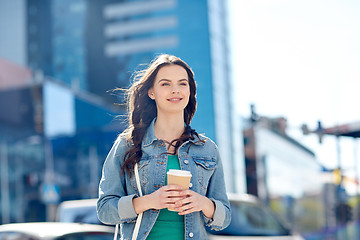 Image showing happy young woman drinking coffee on city street