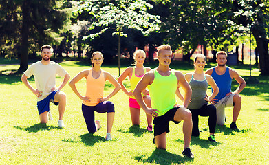 Image showing group of friends or sportsmen exercising outdoors