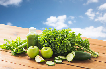 Image showing close up of bottle with green juice and vegetables