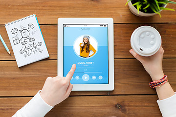 Image showing close up of woman with tablet pc on wooden table