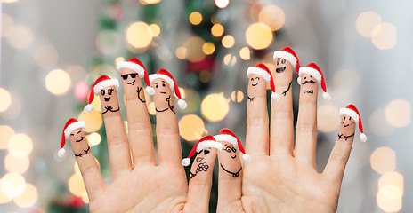 Image showing close up of fingers with smiley in santa hats