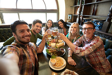 Image showing happy friends taking selfie at bar or pub