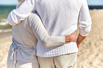 Image showing close up of happy senior couple hugging on beach