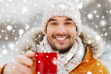 Image showing happy man with tea cup outdoors in winter