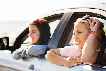 Image showing happy teenage girls or women in car at seaside