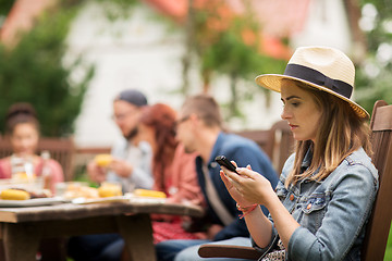 Image showing woman with smartphone and friends at summer party