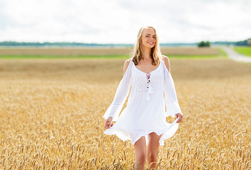 Image showing smiling young woman in white dress on cereal field