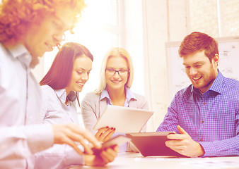 Image showing smiling team with table pc and papers working