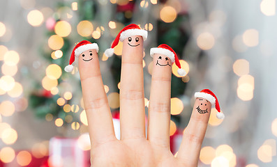 Image showing close up of hand with four fingers in santa hats