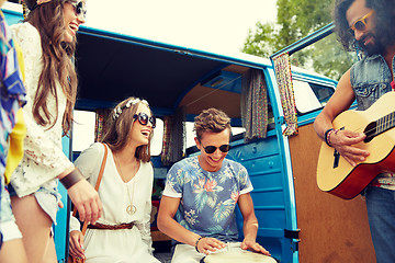 Image showing happy hippie friends playing music over minivan