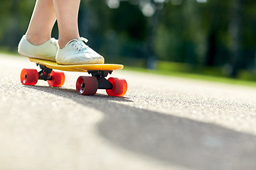 Image showing close up of female feet riding short skateboard