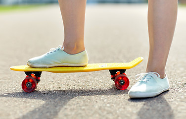 Image showing close up of female feet riding short skateboard