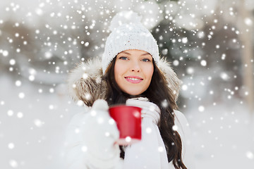 Image showing happy young woman with tea cup outdoors in winter