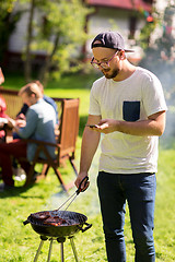 Image showing man cooking meat on barbecue grill at summer party