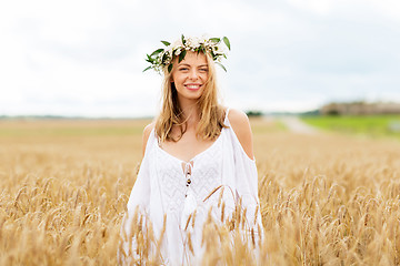 Image showing happy young woman in flower wreath on cereal field