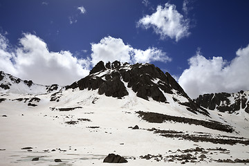 Image showing Frozen mountain lake covered with snow at sun spring day