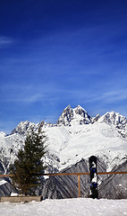 Image showing Snowboard and felled fir-tree on viewpoint at ski resort