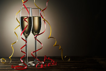 Image showing Two champagne glasses with decorative yellow and red ribbons