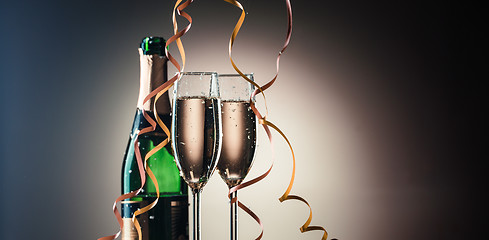 Image showing Bottle of champagne and two filled glasses. Festive composition