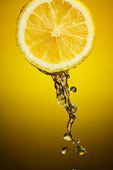 Image showing Sliced lemon with a water dropping from it.