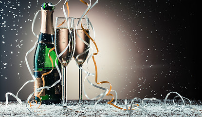 Image showing Two glasses with sparkling champagne and classic green bottle