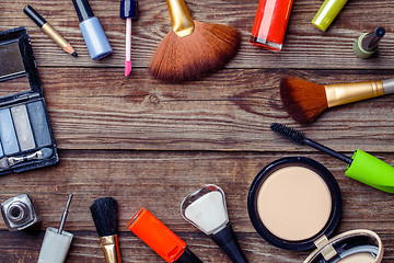 Image showing Various make-up products laid on wooden table. Copy space