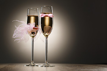 Image showing Champagne glasses decorated pink grooms bow-tie and brides veil