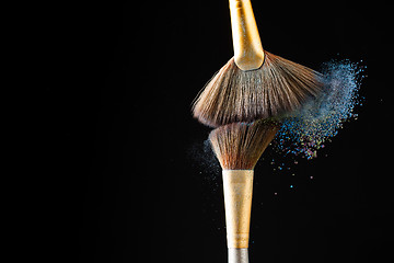 Image showing Make-up brushes with powder isolated on black background