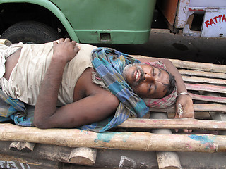 Image showing Indian man asleep waiting for customers to transport their cargo