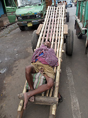 Image showing Indian man asleep waiting for customers to transport their cargo