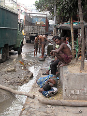 Image showing Streets of Kolkata. Indian people wash themselves on street 