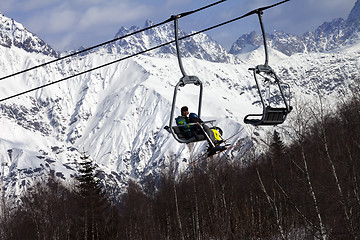 Image showing Skiers on ski-lift and snow mountains at winter sun day