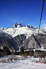 Image showing Chair-lift at ski resort and Mount Ushba in sun day