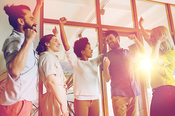 Image showing happy creative team celebrating victory in office