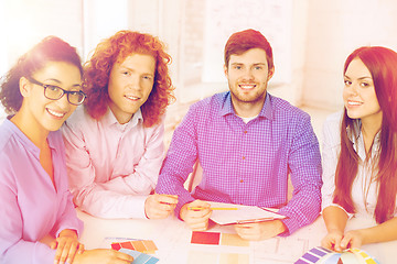 Image showing team with color samples and blueprint at office