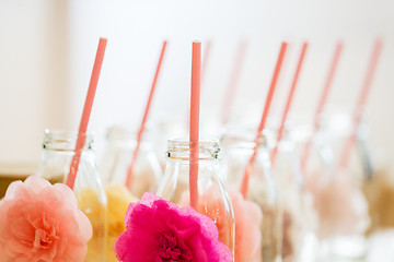 Image showing close up of glass bottles for drinks with straws