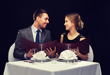 Image showing smiling couple with menus at restaurant