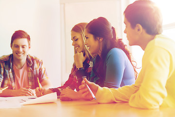 Image showing group of smiling students with blueprint