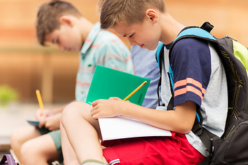 Image showing elementary school students writing to notebooks