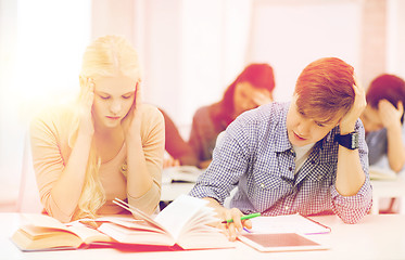 Image showing tired students with tablet pc, notebooks and books