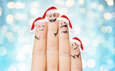 Image showing close up of hand with four fingers in santa hats