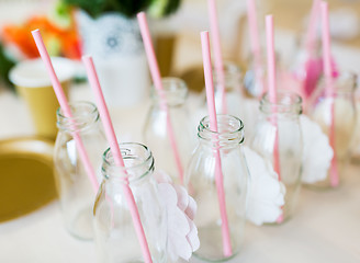 Image showing close up of glass bottles for drinks with straws